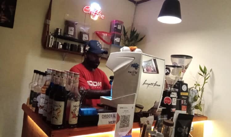Melinus Jikwa di belakang mesin espresso Magic Coffee